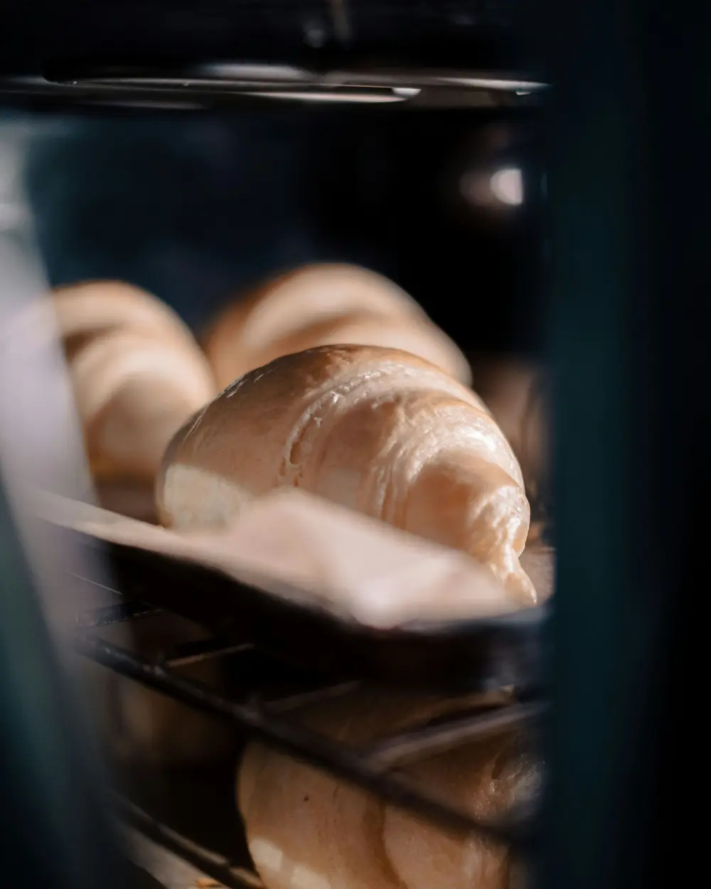 Viennoiseries dorées en pleine cuisson dans le four du fournil